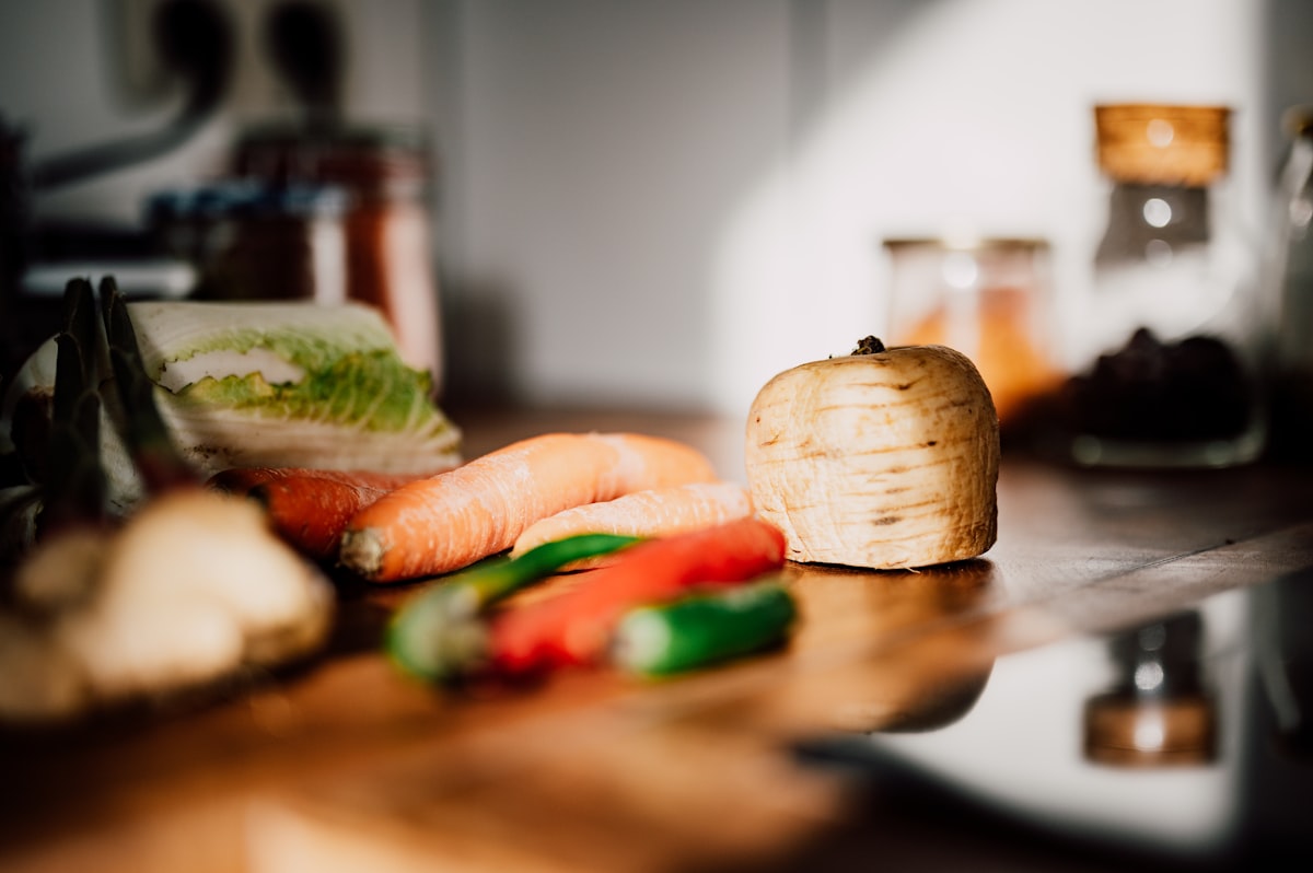 Fresh vegetables and whole ingredients arranged on a wooden table